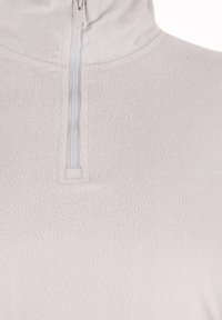 Lichtgrijze fleece top met een rits aan de voorkant tot halverwege. De stof is zacht en textuurrijk, met een hoge kraag en minimale stikseldetails.