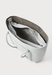 Borsa a mano in pelle grigio chiaro con texture liscia, chiusura con zip e interno con fodera firmata. Include manici corti e strutturati.