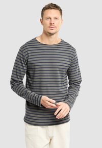 Camicia a maniche lunghe di colore verde oliva con righe orizzontali blu navy, caratterizzata da un colletto a giro e polsini aderenti. Materiale in morbido cotone.