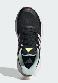 Scarpa da ginnastica nera con tomaia strutturata, dettagli verde chiaro, colletto imbottito e una suola intermedia bianca con particolari rosa.