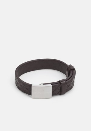 Dark brown leather bracelet featuring a textured woven design and a silver metallic clasp with embossed branding.