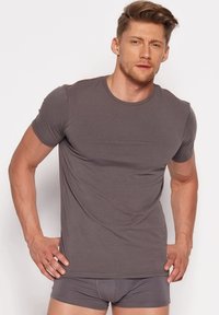 Graues Kurzarm-T-Shirt aus weichem Stoff, mit Rundhalsausschnitt und figurbetontem Schnitt, getragen mit passenden grauen Boxer-Shorts.