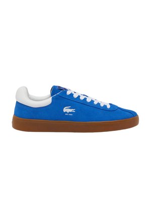 Zapatillas de ante azul con cordones y lengüeta de goma blanca, que cuentan con una suela de goma marrón. Logo de Lacoste en blanco en el lateral.