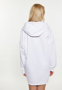 Felpa bianca oversize con cappuccio ampio, spalle scese e polsini a coste. Tessuto morbido con una finitura liscia. Design minimalista.
