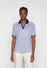 Short-sleeve polo shirt in pink and blue with a geometric pattern. Features a navy collar and cuff accents. Soft fabric with a relaxed fit.