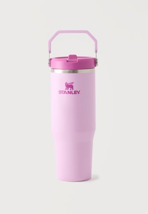 Bicchiere da viaggio isolato alto Stanley rosa con manico pieghevole e coperchio sicuro su sfondo bianco semplice.