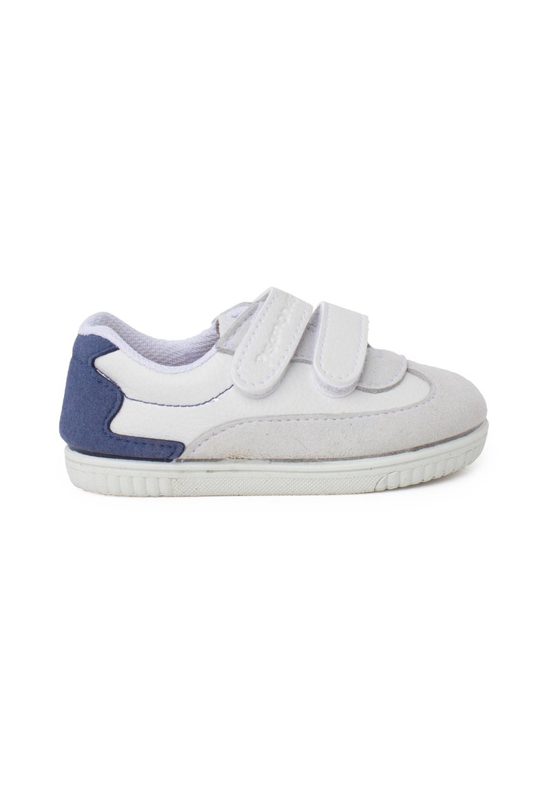Sneaker bianco con un accento in suede blu navy sul tallone. Presenta due cinturini in Velcro, una tomaia in pelle liscia e una suola in gomma testurizzata.