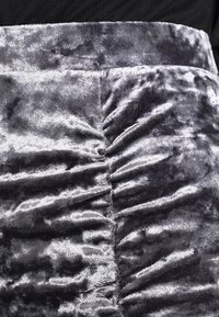 Grijze fluwelen rok met een gerimpeld ontwerp, met een zachte textuur en glans. De stof heeft een gladde, pluizige uitstraling.