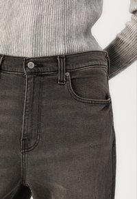 Høytlivs svarte denimjeans med en jevn tekstur, klassisk femlommersdesign og sølvfarges lukking i livet.