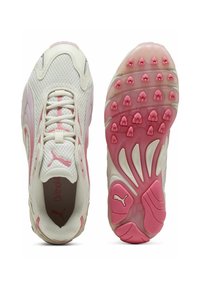 Zapatillas deportivas blancas y rosas con parte superior de malla, suela texturizada con acentos rosas, cordones y un logotipo en el lateral.