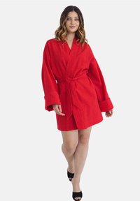 Czerwona, do kolan sięgająca szata wykonana z teksturowanej tkaniny, z szerokimi rękawami i dopasowanym paskiem. Gładki, swobodny krój z dopasowaną talią.