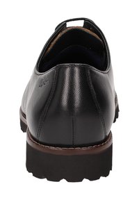 Chaussure en cuir noir avec une texture lisse, un dos arrondi et une semelle en caoutchouc marron. Dispose d'une languette pour un enfilage facile.