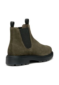 Botas Chelsea de ante verde olivo con paneles laterales elásticos negros y tiradores, que presentan una suela de goma negra resistente y una superficie texturizada.