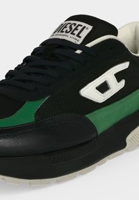 Μαύρο και πράσινο sneaker Diesel με λευκό λογότυπο στο πλάι και επώνυμη ετικέτα στη γλώσσα, με μαύρα κορδόνια και υφασμένο πέλμα.