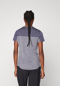 Szara koszulka z krótkim rękawem o wzorze w blokach kolorystycznych, z ciemniejszą górną częścią i jaśniejszym dołem, wykonana z teksturowanej tkaniny.