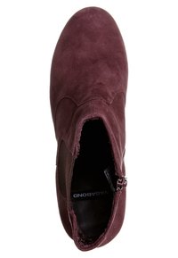 Bottine en daim bordeaux à bout arrondi, fermeture éclair latérale et panneaux élastiques pour un enfiler facile.