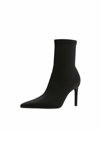 Musta nilkkuri, jossa on terävä kärki, sileä pinta, korkea stiletto-korko ja tiukka muotoilu. Saumadeetalaus reunoilla.