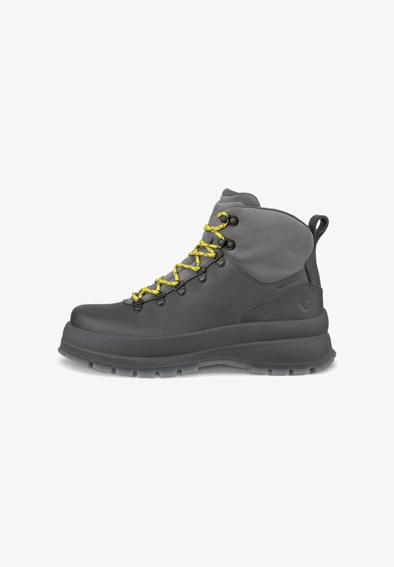Botte de randonnée imperméable gris foncé avec semelle épaisse et lacets jaune vif, vue de côté sur fond blanc.