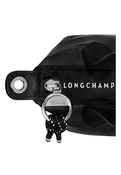 Schwarze Longchamp-Tasche aus Nylonmaterial mit silbernem Reißverschluss, Logo und geflochtenen schwarzen Kordelakzenten. Strukturiertes und elegantes Design.