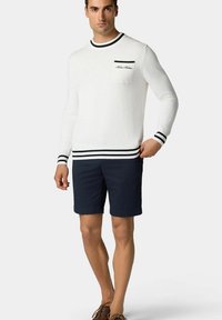 Bílý pletený svetr s námořnickými pruhy na límci a manžetách, s náprsní kapsou. V kombinaci s námořnickými šortkami a hnědými botami.