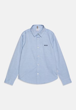 Chemise bleu clair à manches longues avec col, boutons sur le devant, logo "BOSS" brodé sur la poitrine, et une petite étiquette en tissu sur la couture latérale.