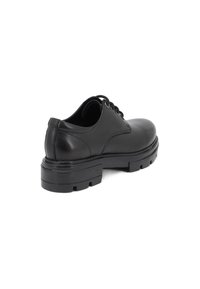 Scarpa in pelle nera con punta arrotondata, design con lacci, suola in gomma robusta e tacco pronunciato. Presenta una texture liscia e accenti minimi.
