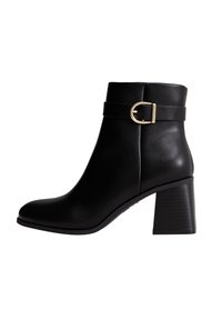 Bottine noire en cuir lisse, avec un bout rond, un talon épais et une sangle décorative à boucle autour de la cheville.