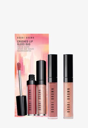 Bobbi Brown Crushed Lip Gloss Duo, jossa kaksi huulikiillotubettia, yksi mauve ja yksi hohtavan ruusukultainen, mustilla kansilla ja aplikaattorilla.