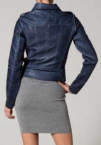 Giacca da biker in pelle blu navy con pannelli laterali texture, cuciture verticali e colletto classico. Finitura liscia e silhouette aderente.
