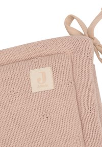 Couverture tricotée en rose doux avec des motifs d'étoiles texturés. Présente une étiquette beige clair avec le logo "Jollein" et un coin noué.
