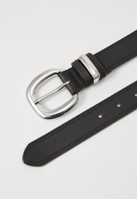 Cinturón de cuero negro con una hebilla rectangular plateada brillante. Presenta costuras a lo largo de los bordes y varios agujeros para un ajuste personalizado.