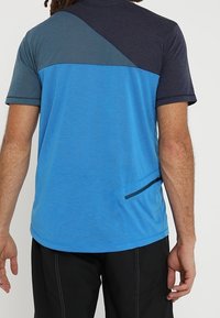 Tričko s krátkým rukávem s modro-námořnickým panelem, s hladkým povrchem a boční kapsou na zip.