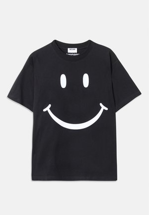 T-shirt noir à manches courtes en coton avec un grand graphisme de smiley blanc à l'avant. Encolure ronde classique.
