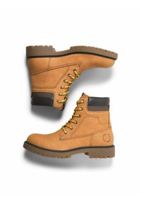 Světle hnědé kožené boty se žlutými tkaničkami, polstrovaným límcem a gumovou podrážkou. Obsahují vyztužené švy a detail v podobě kruhového loga.