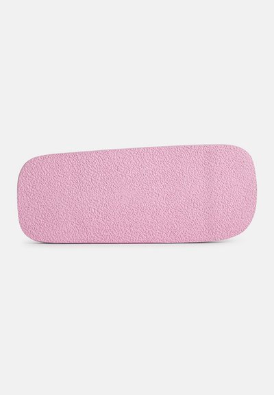 Semelle en caoutchouc rose avec une surface texturée, des bords arrondis et une forme légèrement courbée. Couleur uniforme sur toute la surface.