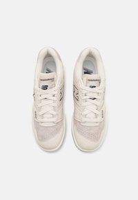 Bílé tenisky kombinující kůži a nubuk, s perforovanou špičkou, tkaničkami, polstrovaným límcem a velkým šedým logem "N".