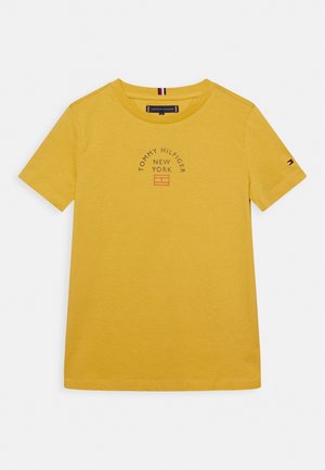 T-shirt in cotone giallo con maniche corte, scollo rotondo e piccolo logo "Tommy Hilfiger New York" stampato in lettere scure.