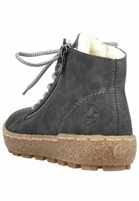 Bottine grise en cuir avec doublure en fausse fourrure, semelle en caoutchouc texturée et design métallique à lacets. Dispose d'une fermeture éclair pour un enfilage facile.