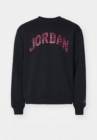 Felpa nera con la scritta "JORDAN" in testo a quadri multicolori sul retro e un piccolo logo sulla manica sinistra. Design semplice con scollo rotondo.