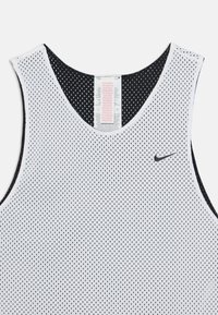 Biały siateczkowy top sportowy z czarnym wykończeniem, posiadający okrągły dekolt oraz małe czarne logo Nike z przodu. Metka pielęgnacyjna widoczna w środku.