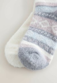 Puha, bolyhos zoknik fehér és pasztell csíkos mintázattal, világoskék, levendula és szürke kiegészítőkkel. Kerek orrú kialakítás.