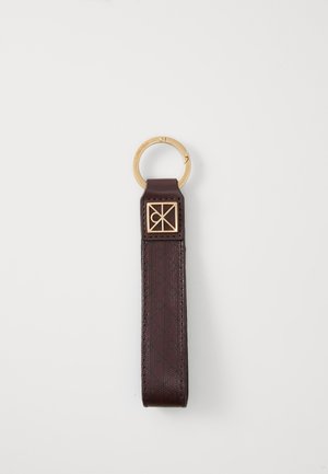 Porte-clés en cuir marron avec un anneau en métal doré, comportant un accent de logo carré et un motif texturé embossé le long de la lanière.