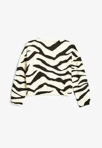 Sweatshirt noir et blanc à motifs zèbre, avec des manches longues à poignets élastiques et un col arrondi.