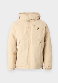 Beige letvægtsjakke med hætte, der har lynlås lukning, elastiske manchetter og et lille sort og gult logo på brystet.