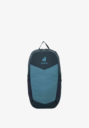 Zaino in tessuto blu navy e verde teal, caratterizzato da un design triangolare con dettagli in rete, maniglia superiore, doppie cerniere e un logo sul davanti.
