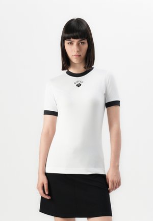 White short-sleeve t-shirt with black collar and sleeve accents. Features a small black embroidered logo on the chest. Smooth texture.