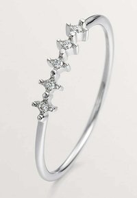 Anillo de plata con cinco engastes en forma de estrella que contienen piedras preciosas transparentes, banda delgada, acabado pulido y textura suave.