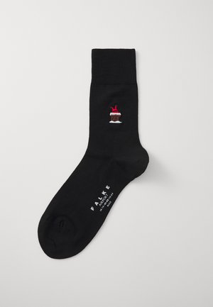 Schwarze Baumwollsocke mit einem kleinen bestickten Kuchendesign an der Seite, mit einer roten Kirsche und weißen Zuckergussdetails. Branding in Weiß aufgedruckt.