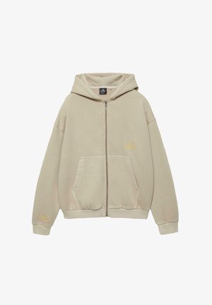 Beżowa bluza z kapturem na zamek, wykonana z miękkiego materiału, z dużą przednią kieszenią, kapturem ze sznurkiem i małym żółtym logo na piersi.