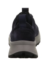 Vista posteriore di una sneaker di colore blu scuro con una suola spessa grigia e battistrada nero, dotata di linguette in tessuto sul colletto del tallone.